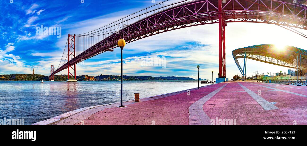 Photographie panoramique du pont de 25 de Abril dans la ville de Lisbonne au-dessus du fleuve Tajo.Paysage de Lisbonne au coucher du soleil Banque D'Images