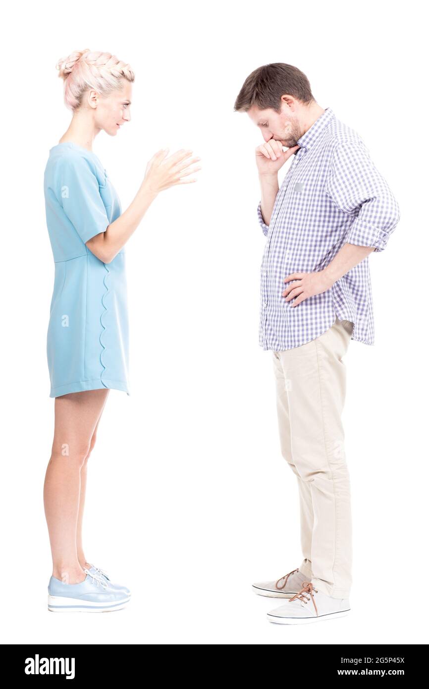 Vue verticale sur le côté plein studio prise de vue de jeune femme adulte en colère se querellant avec son mari, fond blanc Banque D'Images