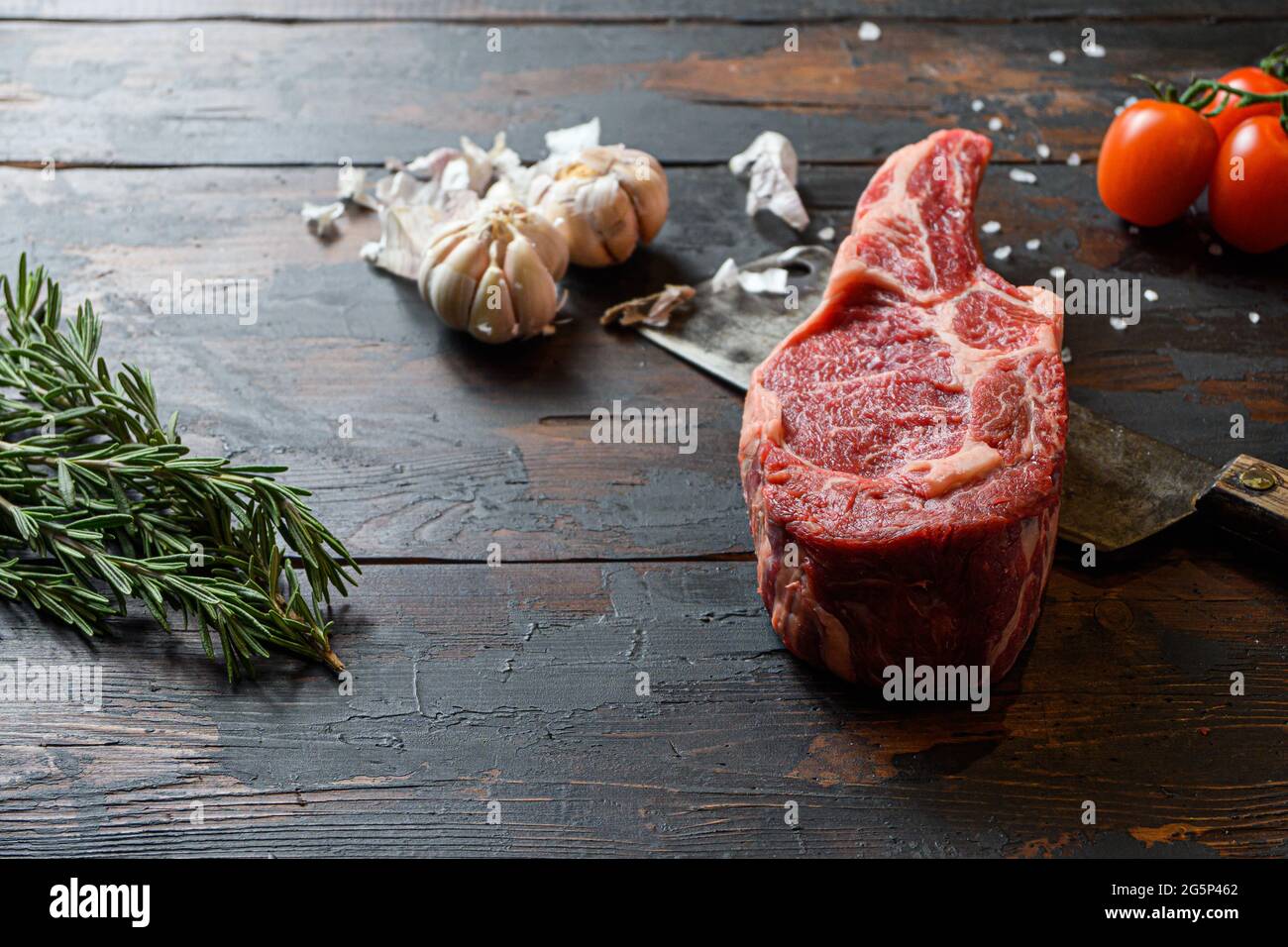 Bœuf cru Dallas steak, qui se trouve sur le couteau de coupe. Viande de bœuf crue préparée pour la cuisson des steaks. À côté des ingrédients pour la cuisson des steaks, épices a Banque D'Images