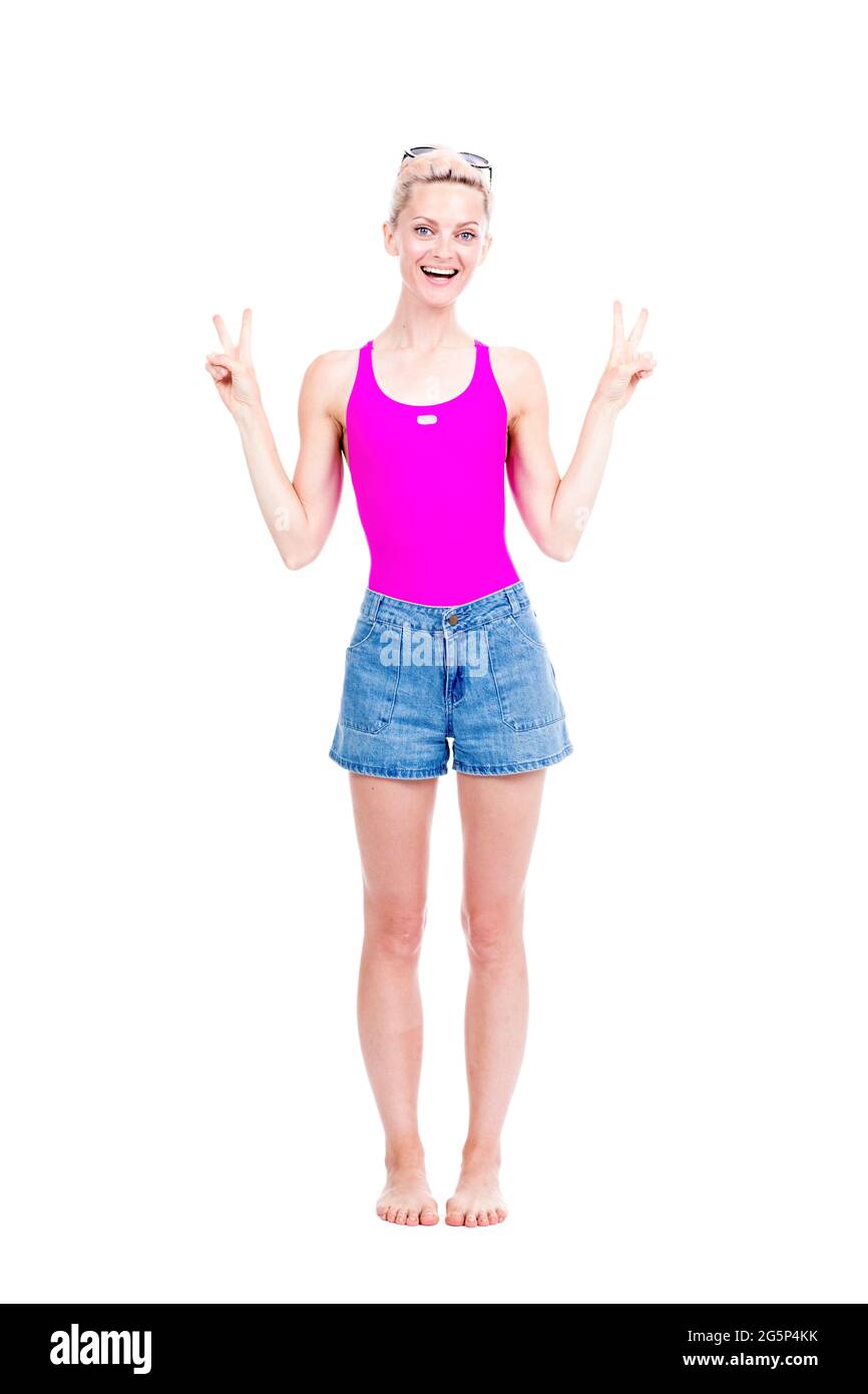 Portrait de studio vertical pleine longueur de belle jeune femme caucasienne portant la tenue d'été posant sur l'appareil photo, fond blanc Banque D'Images