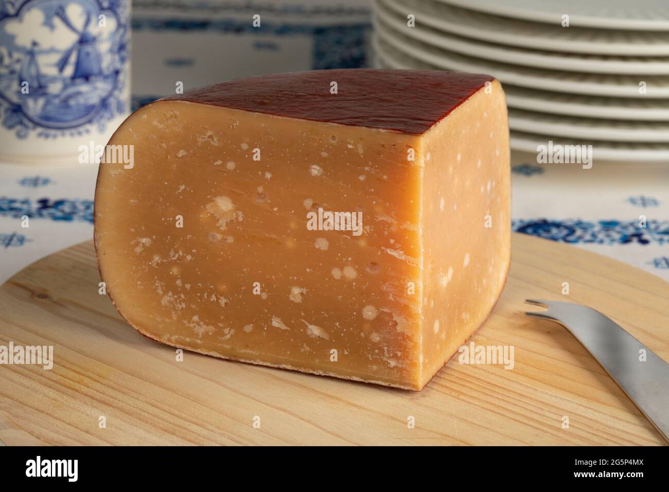 Coin de vieux fromage de brebis hollandais mûr sur une planche à découper Banque D'Images