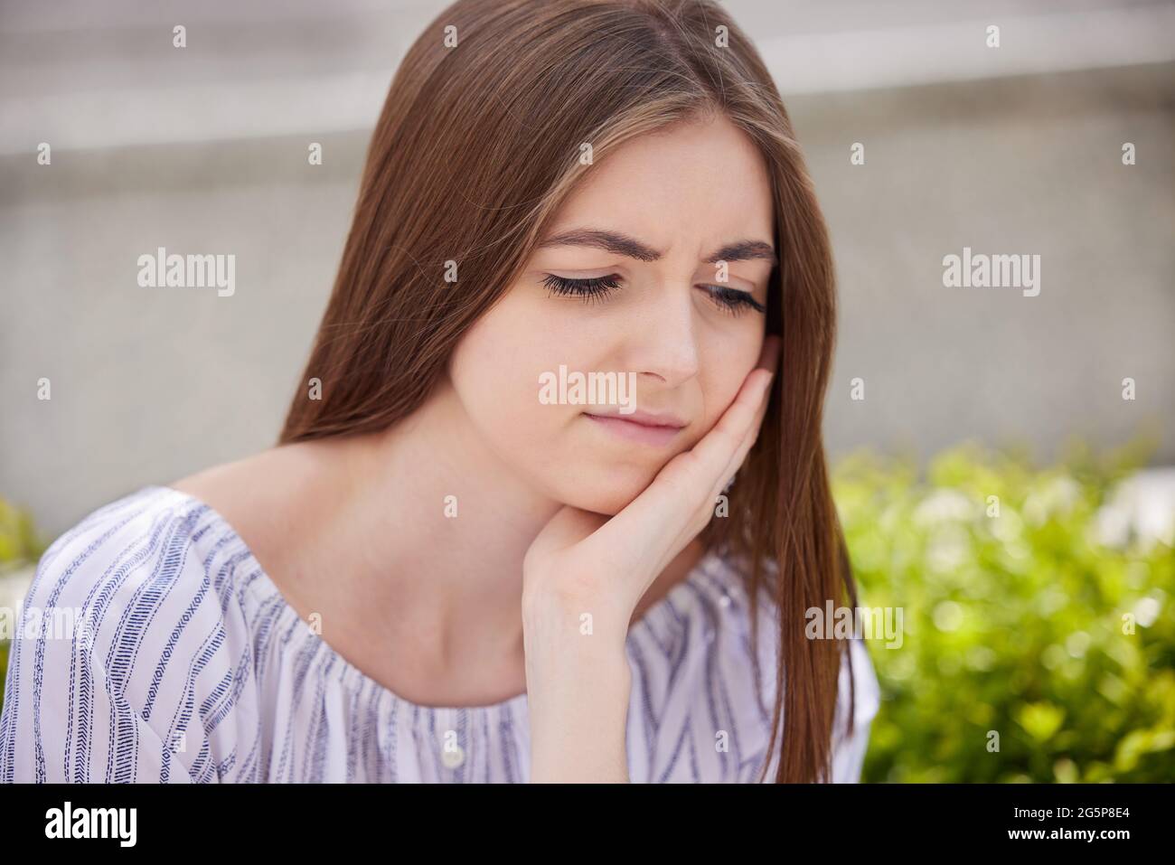Portrait de la jeune femme inquiète souffrant de dépression avec la tête dans les mains à l'extérieur Banque D'Images