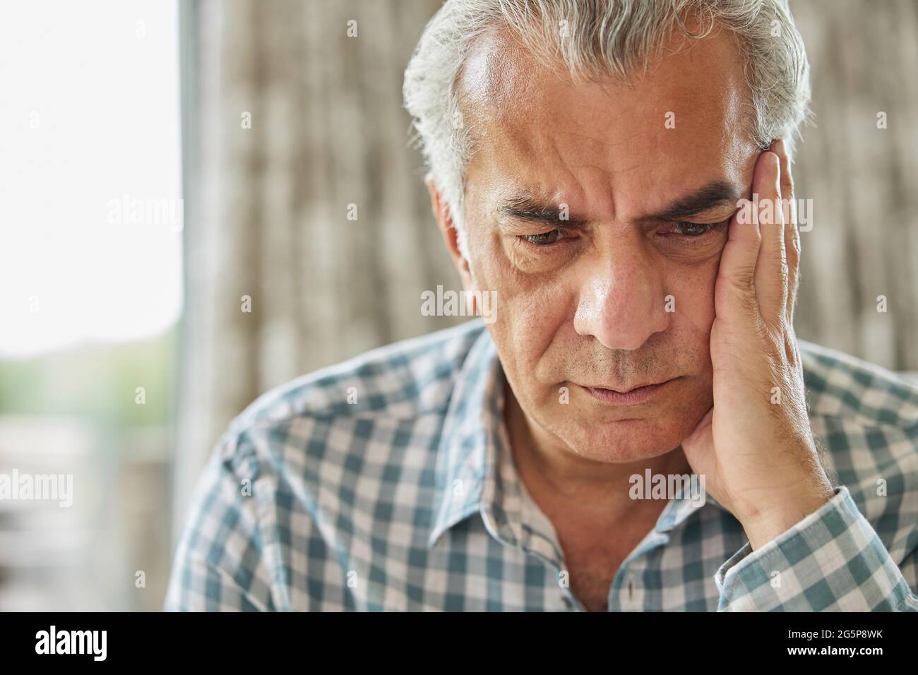 Tête et épaules prise de vue d'un homme senior inquiet à la maison Banque D'Images