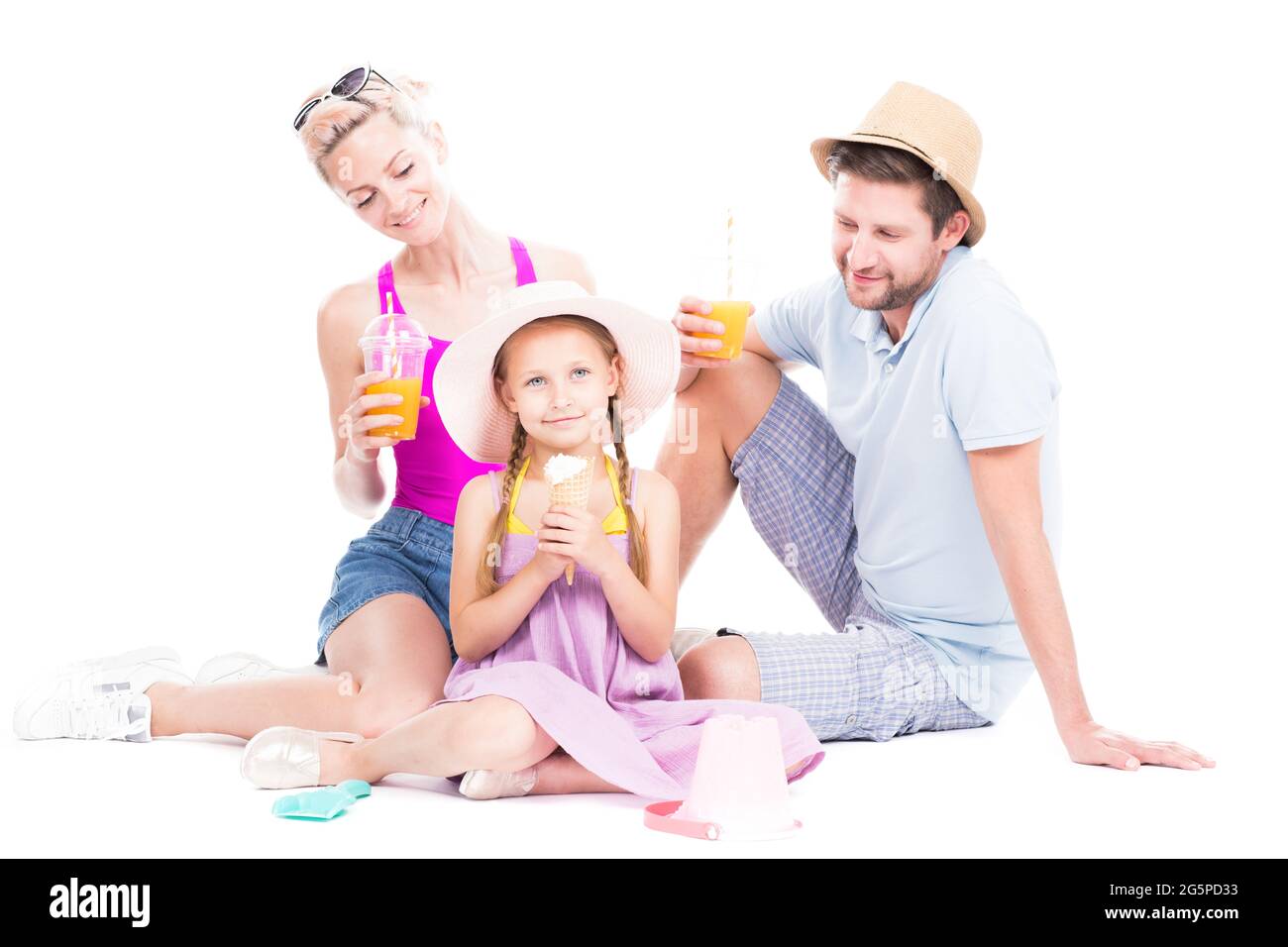 Portrait de famille en studio horizontal avec une jolie fille portant des tenues d'été assis sur le sol, boire du jus et manger de la crème glacée, fond blanc Banque D'Images