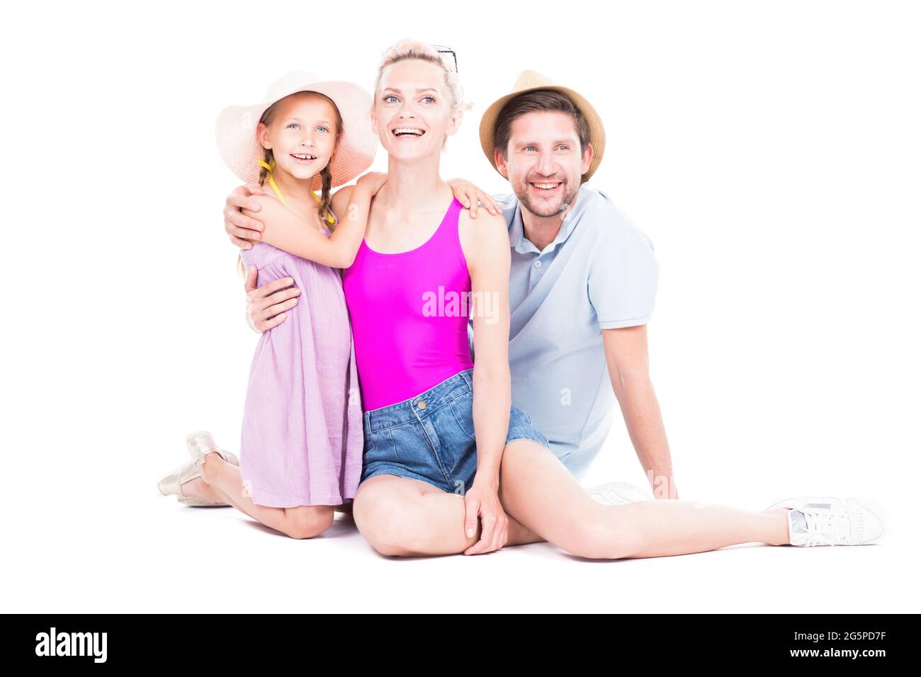 Portrait de famille en studio horizontal avec une jolie fille portant des tenues d'été assise sur le sol, fond blanc Banque D'Images