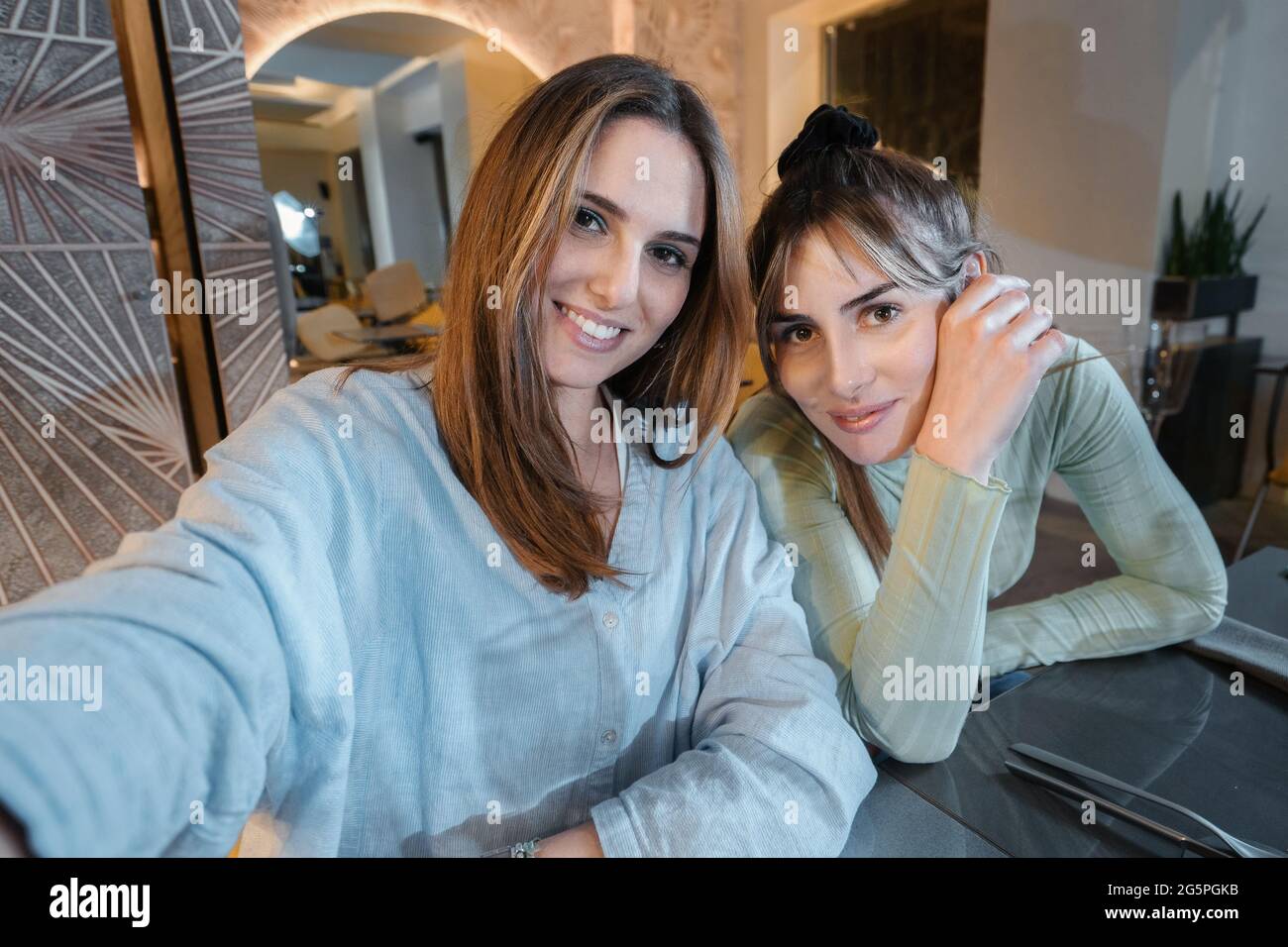 Une paire de jeunes meilleures amies femmes prennent un selfie à la table du restaurant. Concept d'amitié des femmes seulement. Banque D'Images