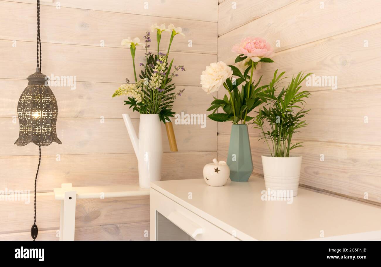 Bouquets romantiques festifs de pivoines blanches et roses sur fond de mur blanc en bois, style scandinave. Arrière-plan de mariage Banque D'Images