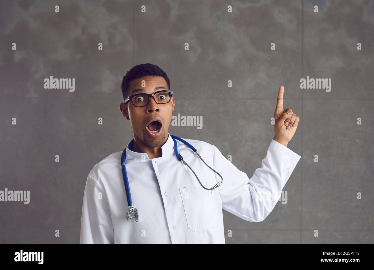 Un médecin américain afro-américain choqué pointe vers le haut le portrait du studio Banque D'Images
