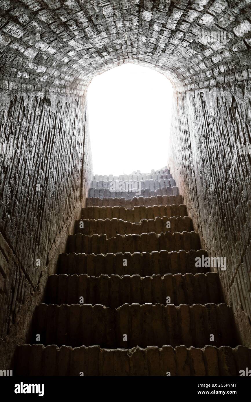 Concept abstrait de la mort ou de la vie après la mort. Escalier en pierre menant à la lumière vive Banque D'Images