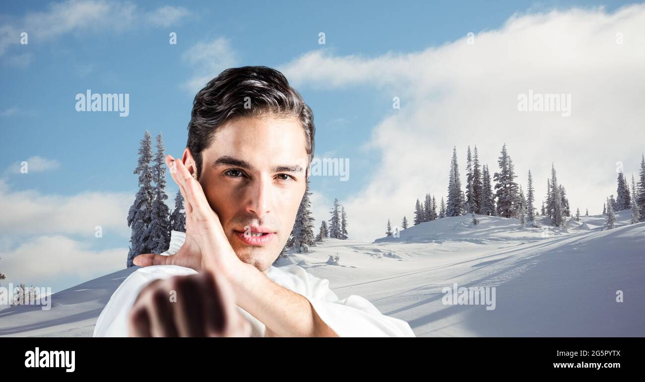 Image numérique composite du portrait de l'artiste marital masculin du caucase par rapport au paysage hivernal Banque D'Images