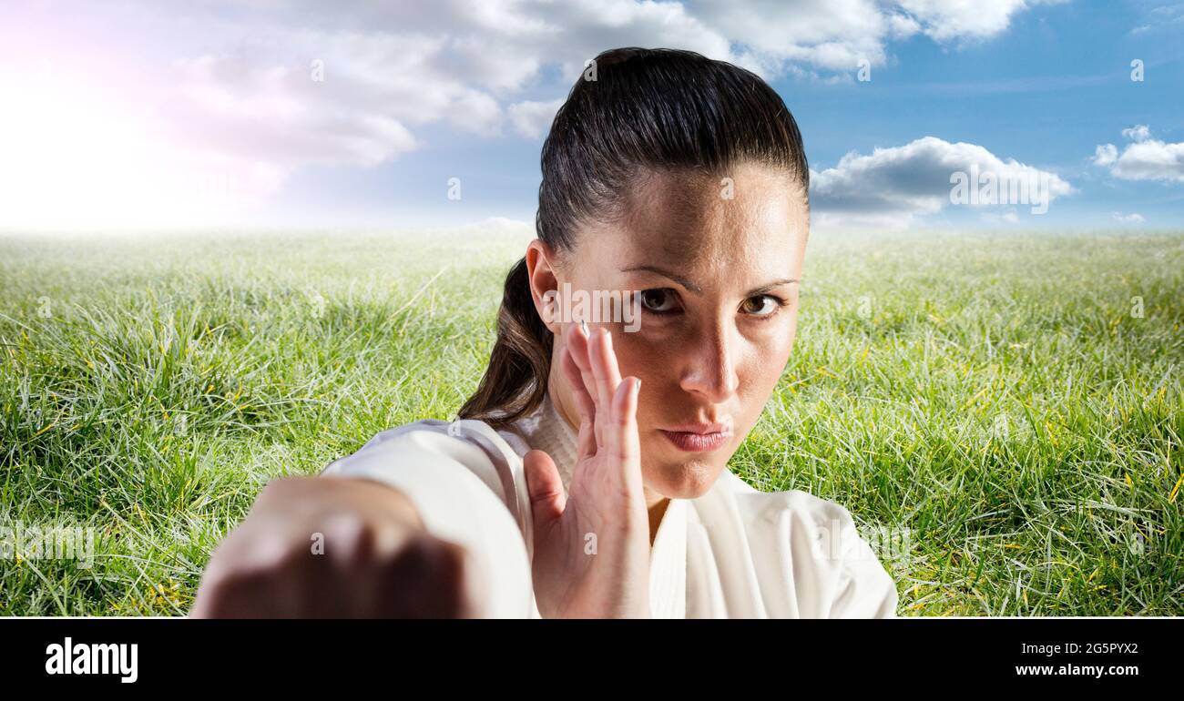 Image numérique composite du portrait d'une femme mariteuse caucasienne contre l'herbe et le ciel bleu Banque D'Images