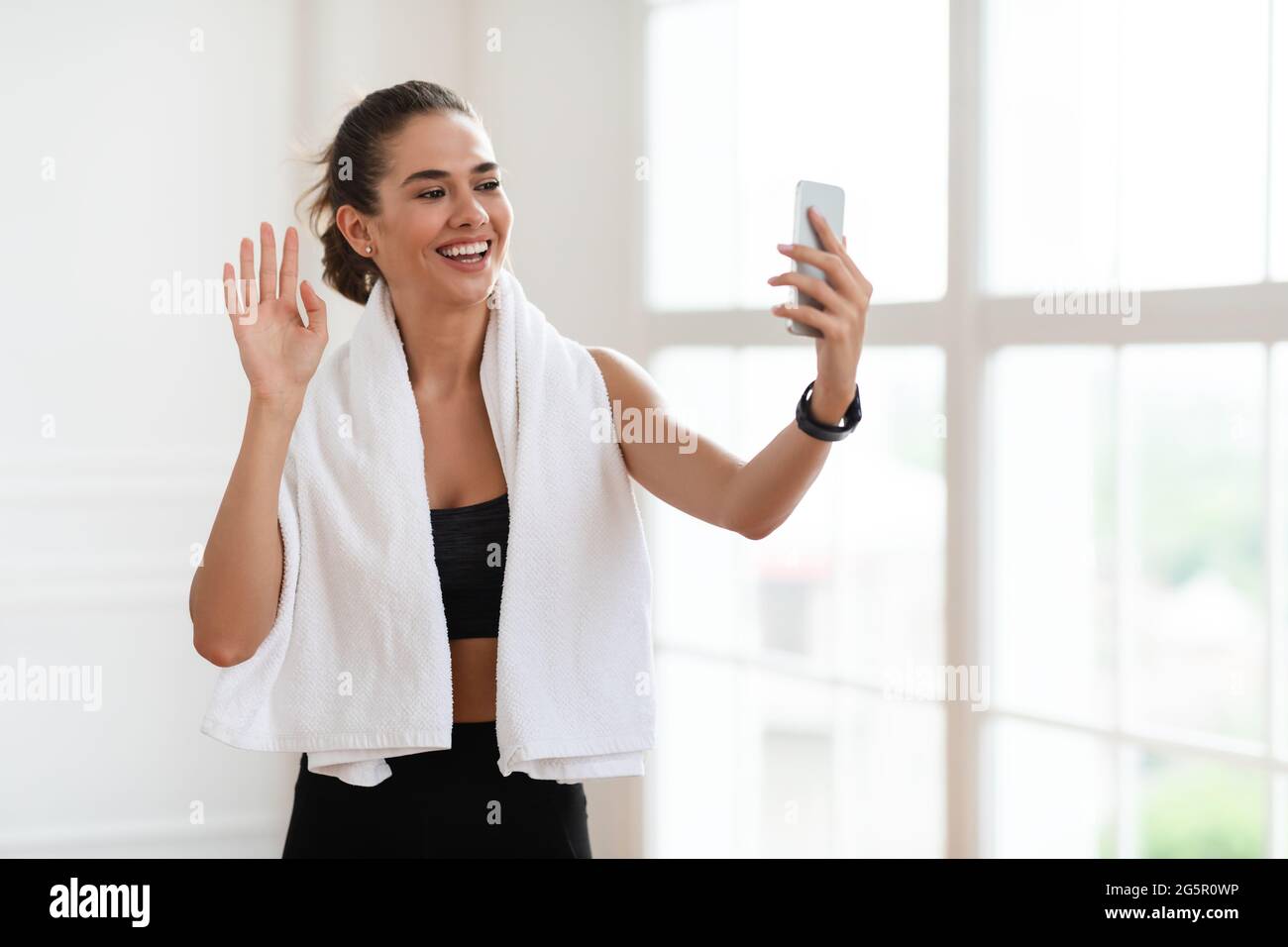 Jeune femme s'entraînant et agitant à l'écran du smartphone Banque D'Images