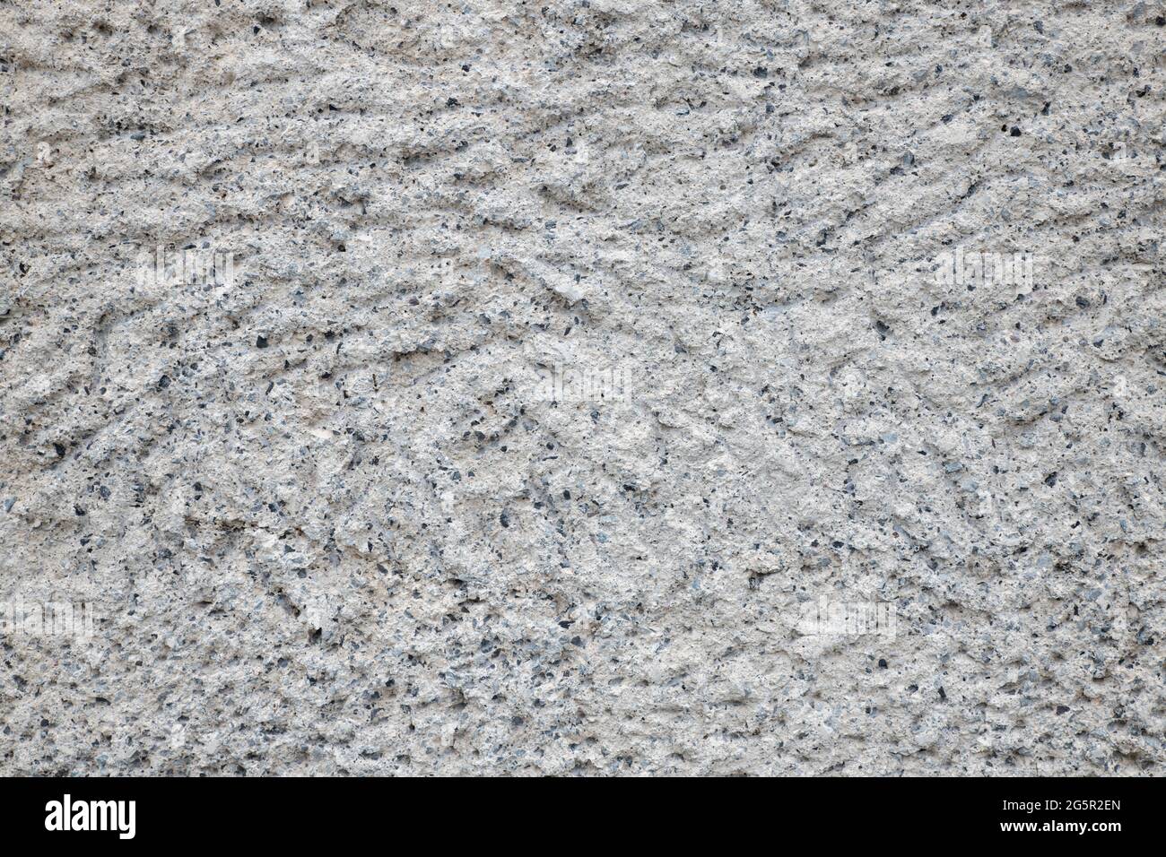 Mur calcaire gris rugueux, fond neutre avec texture grossière et pores noirs, inspiration de fond minéral et idées de mur de pierre, architecture Banque D'Images