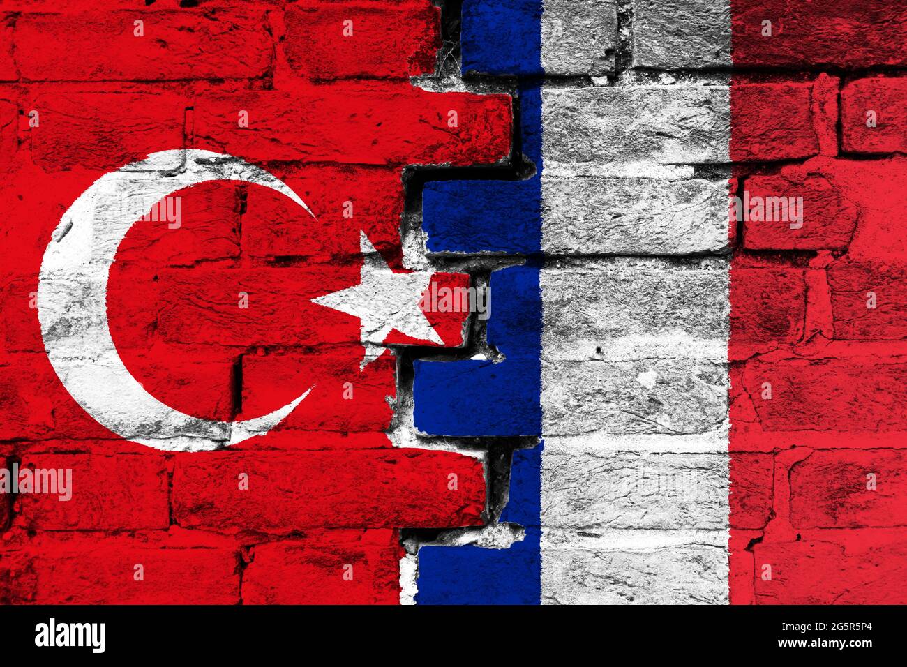 Concept de la relation entre la Turquie et la France avec deux drapeaux peints sur un mur de briques endommagé Banque D'Images