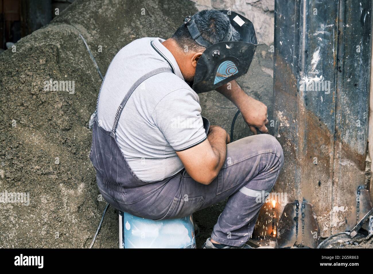 Soudeur soudant une colonne métallique sur le chantier de construction Banque D'Images