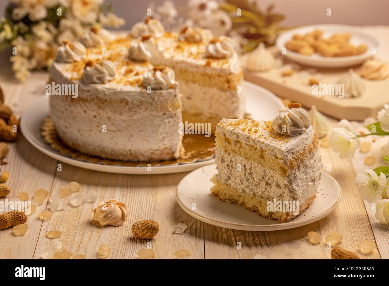 Gâteau rond avec crème fouettée et noix. Une glace est retirée et placée sur une plaque en porcelaine Banque D'Images