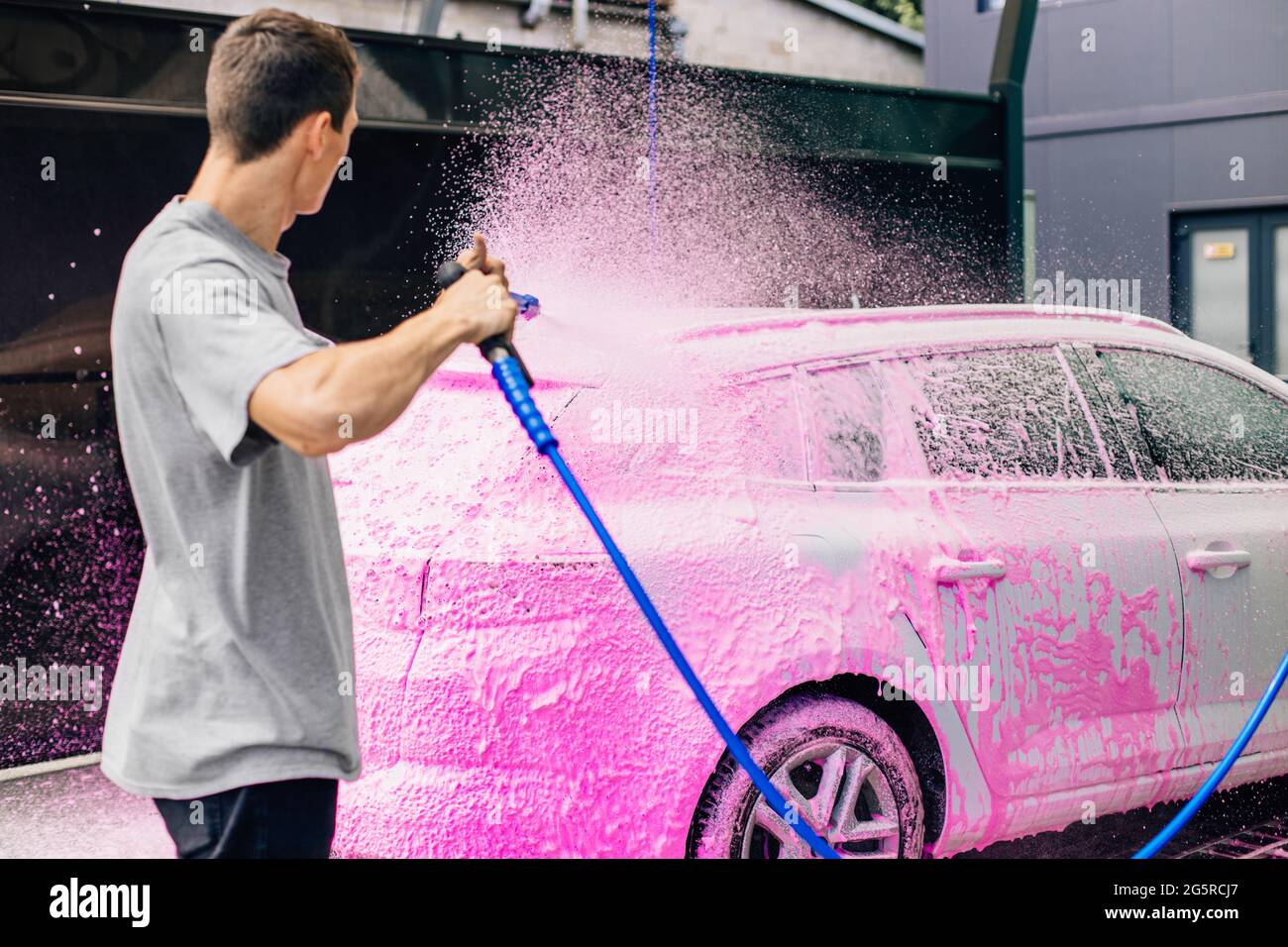 Lavage de voiture avec du savon, nettoyage de voiture avec de l'eau haute  pression, un homme lave la voiture, lave la mousse avec de l'eau Photo  Stock - Alamy