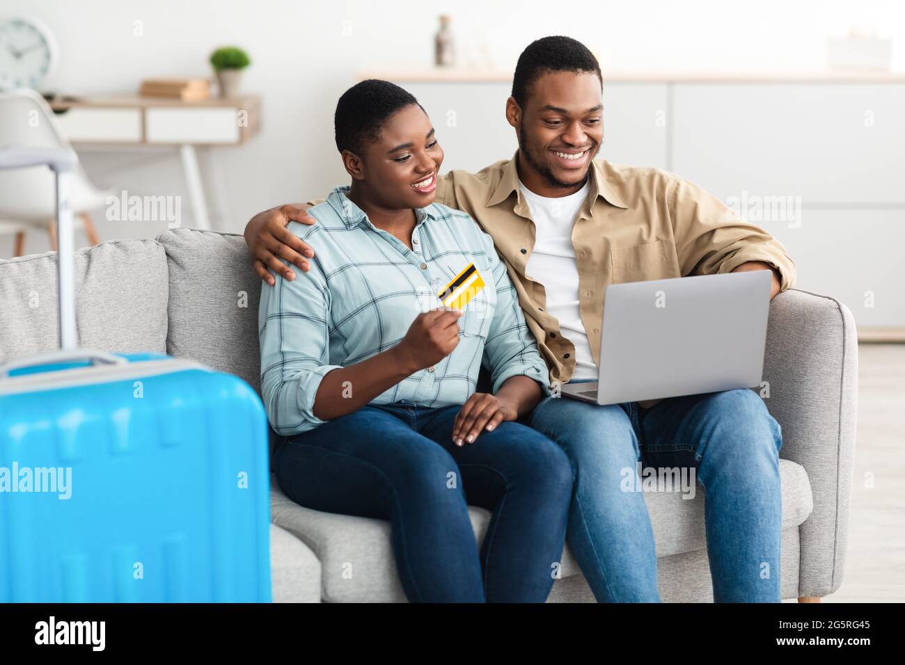 Black couple Acheter des billets de voyage en ligne en utilisant l'ordinateur portable à la maison Banque D'Images