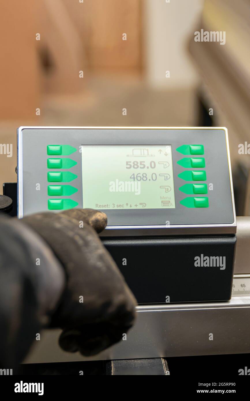 Processus de programmation d'une machine CNC. Saisie de données dans une machine contrôlée par ordinateur. L'opérateur de la machine CNC saisit les données. Banque D'Images