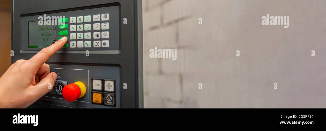 Processus de programmation d'une machine CNC. Saisie de données dans une machine contrôlée par ordinateur. L'opérateur de la machine CNC saisit les données. Banque D'Images