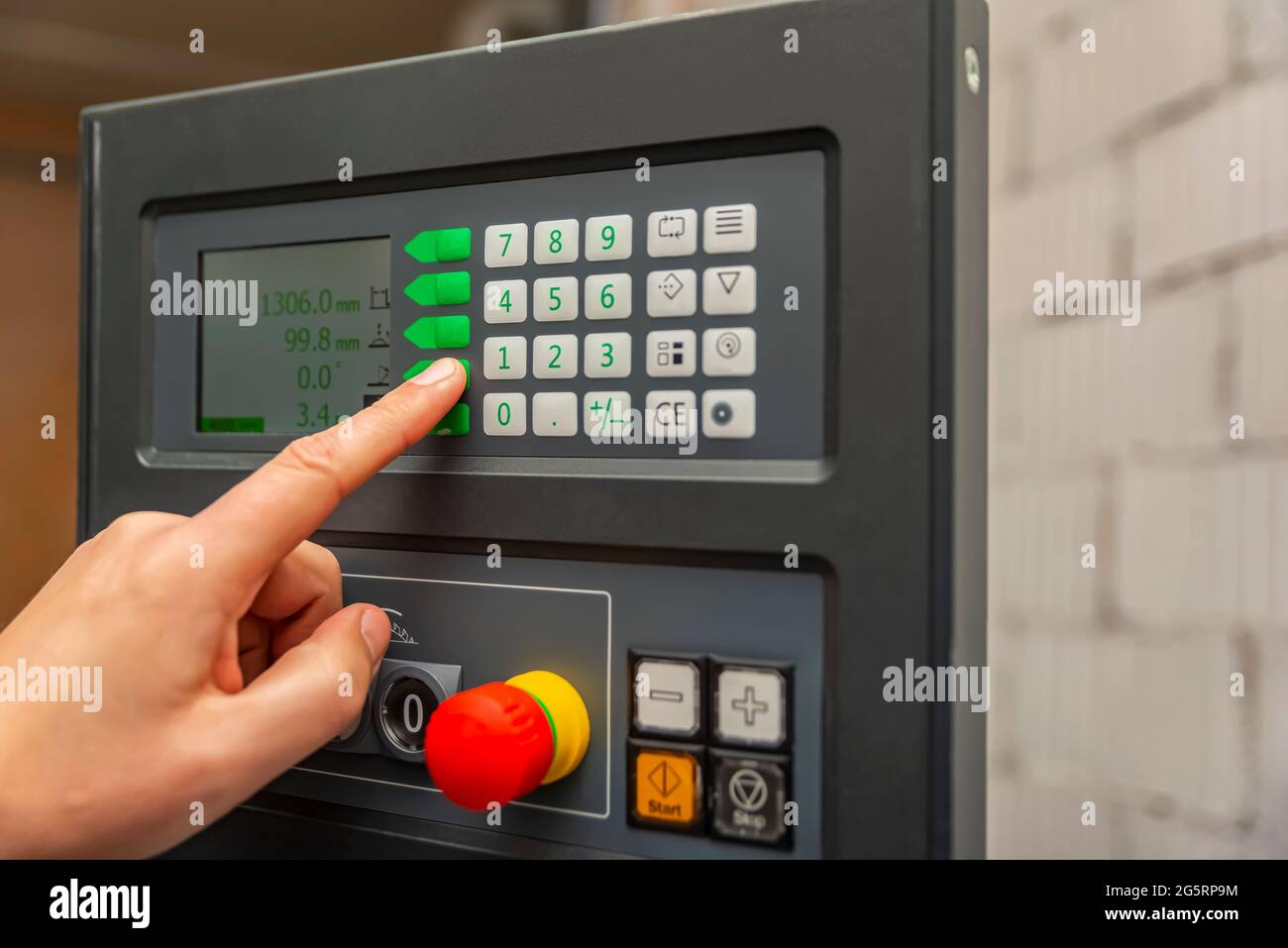 Processus de programmation d'une machine CNC. Saisie de données dans une machine contrôlée par ordinateur. L'opérateur de la machine CNC saisit les données. Banque D'Images