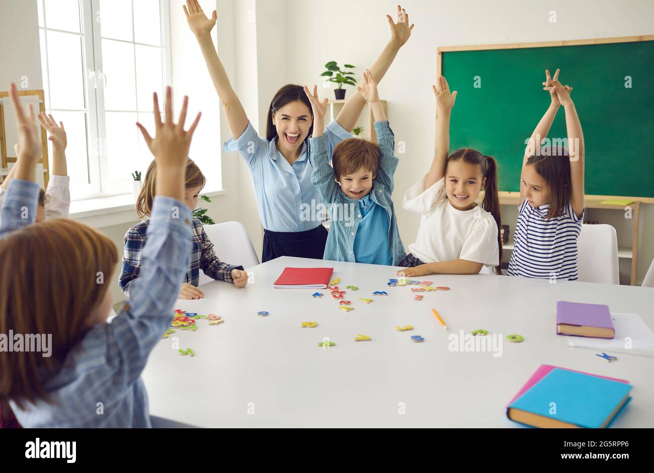 Le groupe préscolaire exécute la tâche avec l'enseignant. Banque D'Images