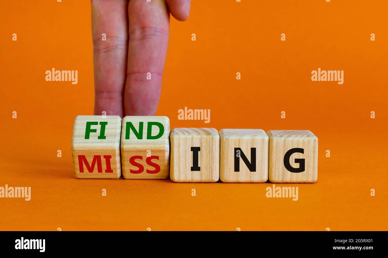 Symbole de recherche ou manquant. Homme d'affaires tourne des cubes en bois et change le mot manquant à la conclusion. Magnifique arrière-plan orange. Affaires, trouver ou m Banque D'Images