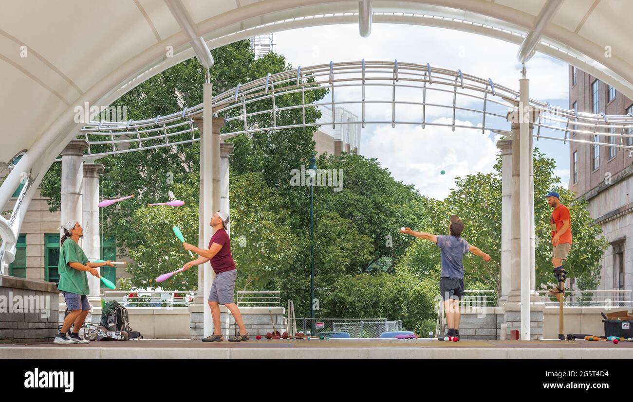 ASHEVILLE, NC, USA-27 juin 2021 : quatre hommes sur la scène Bascom Lamar Lunsford à Pack Square, pratiquant le jonglage et la marche sur pilotis. Banque D'Images