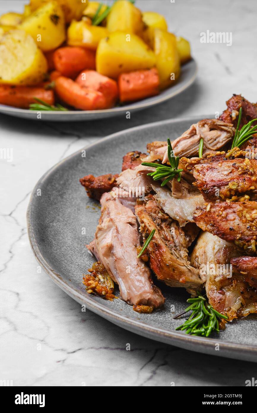 Vue rapprochée de la viande d'épaule d'agneau tirée cuite au four avec pomme  de terre et carotte sur une table en marbre Photo Stock - Alamy