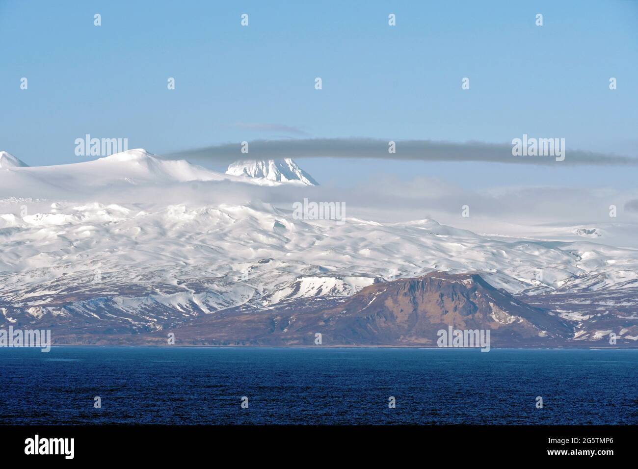 Montagnes couvertes de neige dans les îles Aléoutiennes comme partie de la chaîne d'îles en Alaska. Banque D'Images
