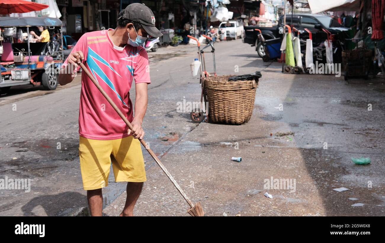 Klong Toey Market Wholesale Wet Market Bangkok Thaïlande le plus grand centre de distribution alimentaire en Asie du Sud-est balayeuse de rue faisant des travaux d'assainissement Banque D'Images