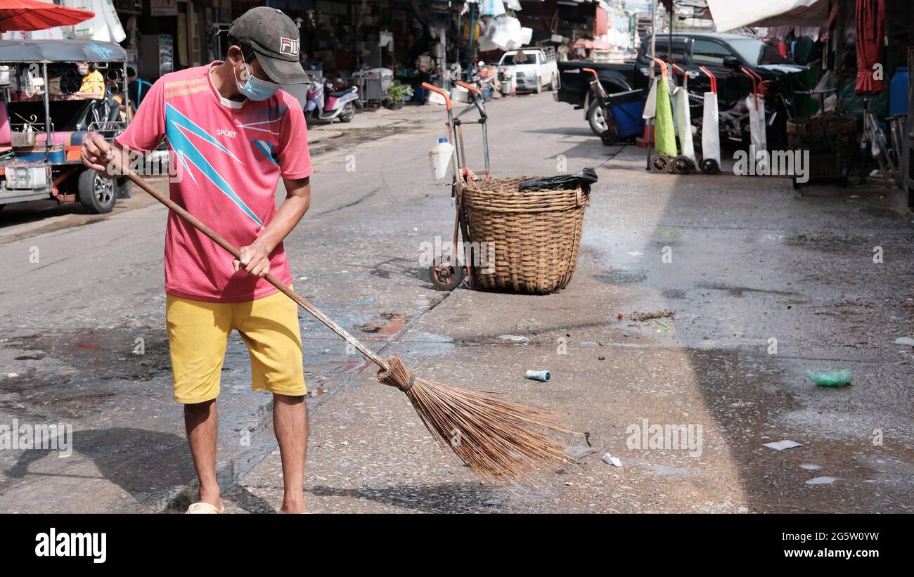 Klong Toey Market Wholesale Wet Market Bangkok Thaïlande le plus grand centre de distribution alimentaire en Asie du Sud-est balayeuse de rue faisant des travaux d'assainissement Banque D'Images