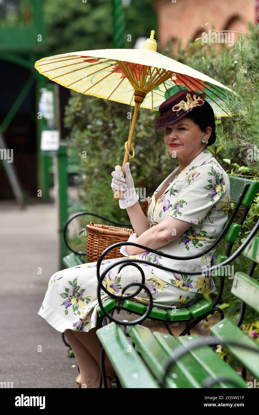 Femme sur la plate-forme de la gare dans les années 1940 robe pendant l'événement annuel de la guerre sur la ligne, Alresford, Hampshire, Royaume-Uni. 13 juin 2021. Banque D'Images