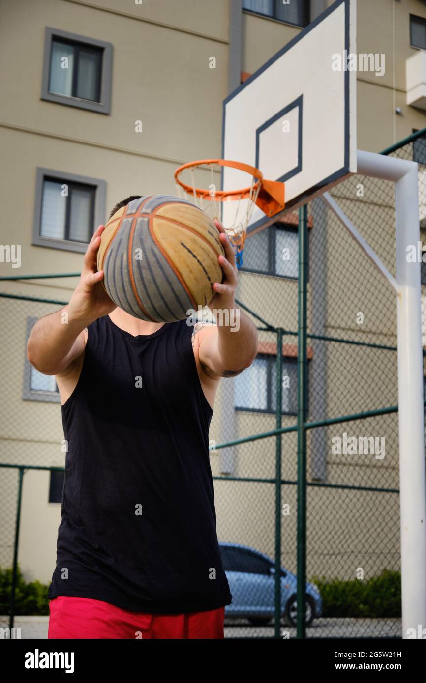 L'homme joue au basket-ball sur le terrain extérieur Banque D'Images