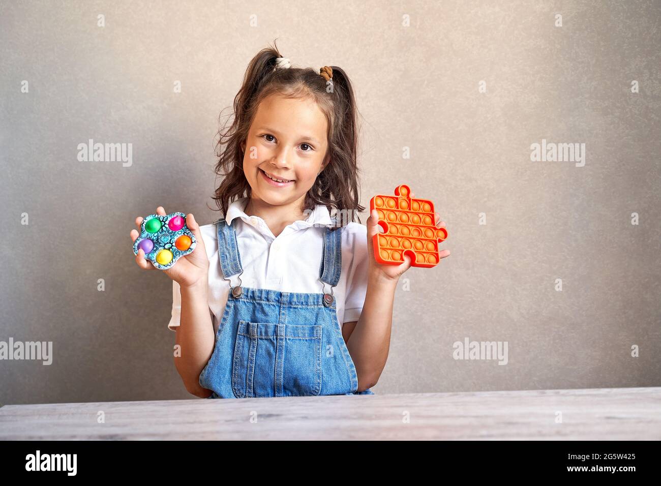 une belle fille sourit en tenant un pop il mains. Banque D'Images