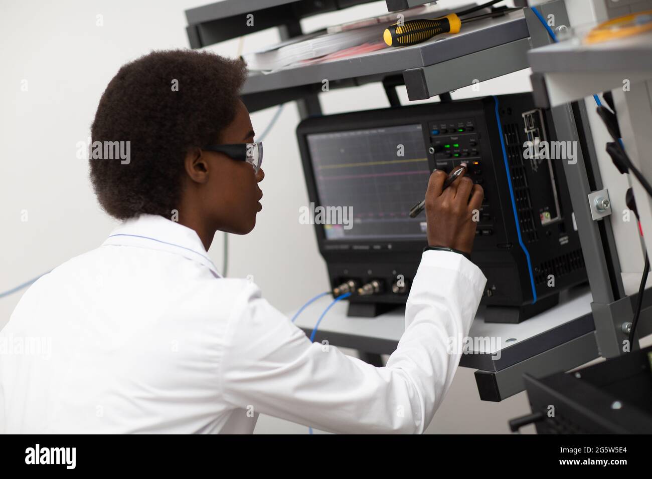 Scientifique afro-américaine femme travaillant en laboratoire avec l'oscillographe. Recherche et développement de dispositifs électroniques par couleur noire femme. Banque D'Images