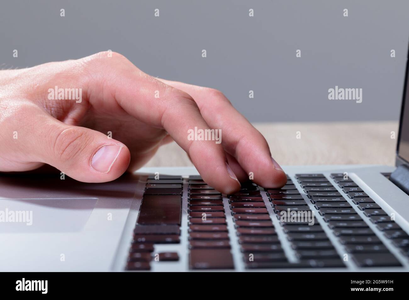 Gros plan de l'homme d'affaires caucasien tapant sur le clavier, isolé sur fond gris Banque D'Images