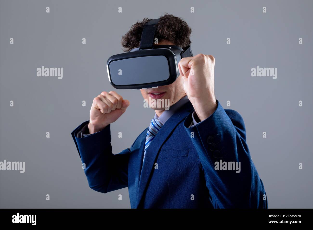 Homme d'affaires caucasien portant un casque vr, isolé sur fond gris Banque D'Images