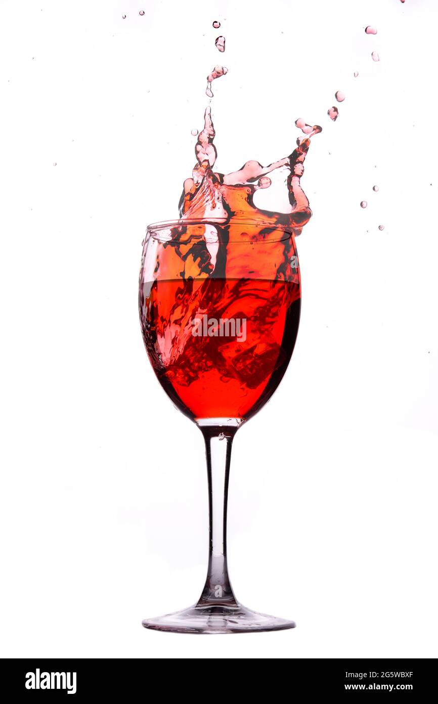 Vin rouge éclaboussant sur fond blanc Banque D'Images