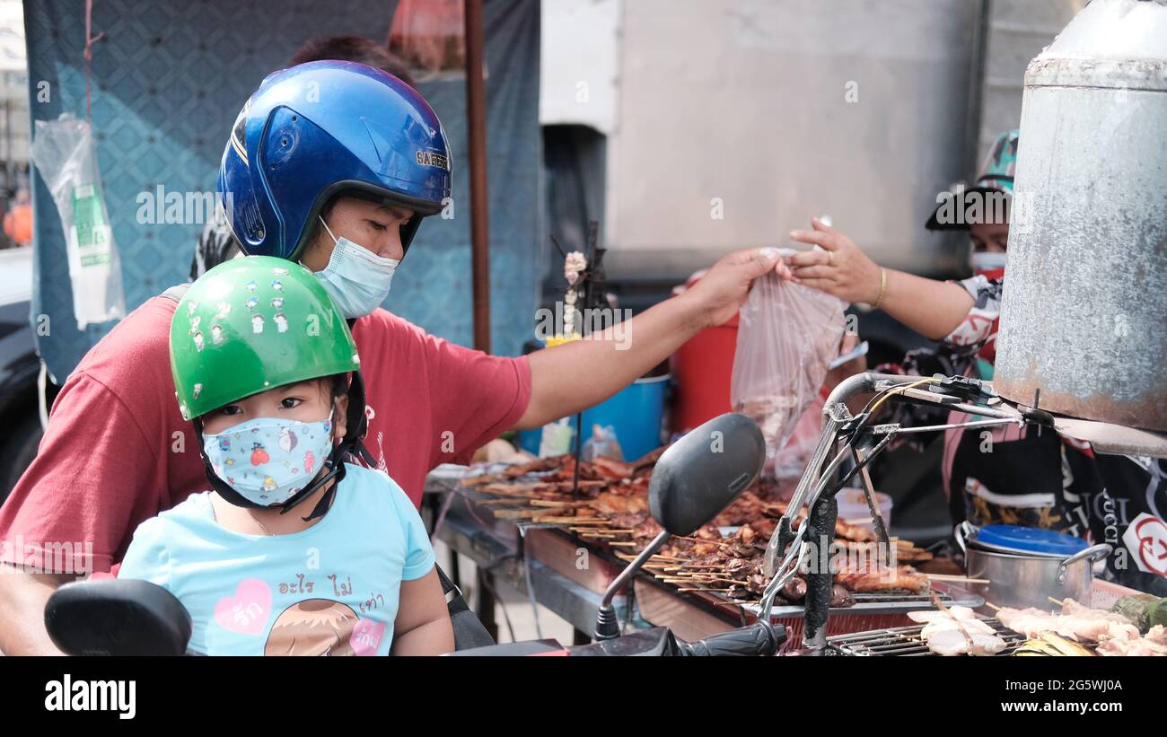 Père et fille sur une moto Klong Toey Market Wholesale Wet Market Bangkok Thaïlande argent changeant de mains Banque D'Images