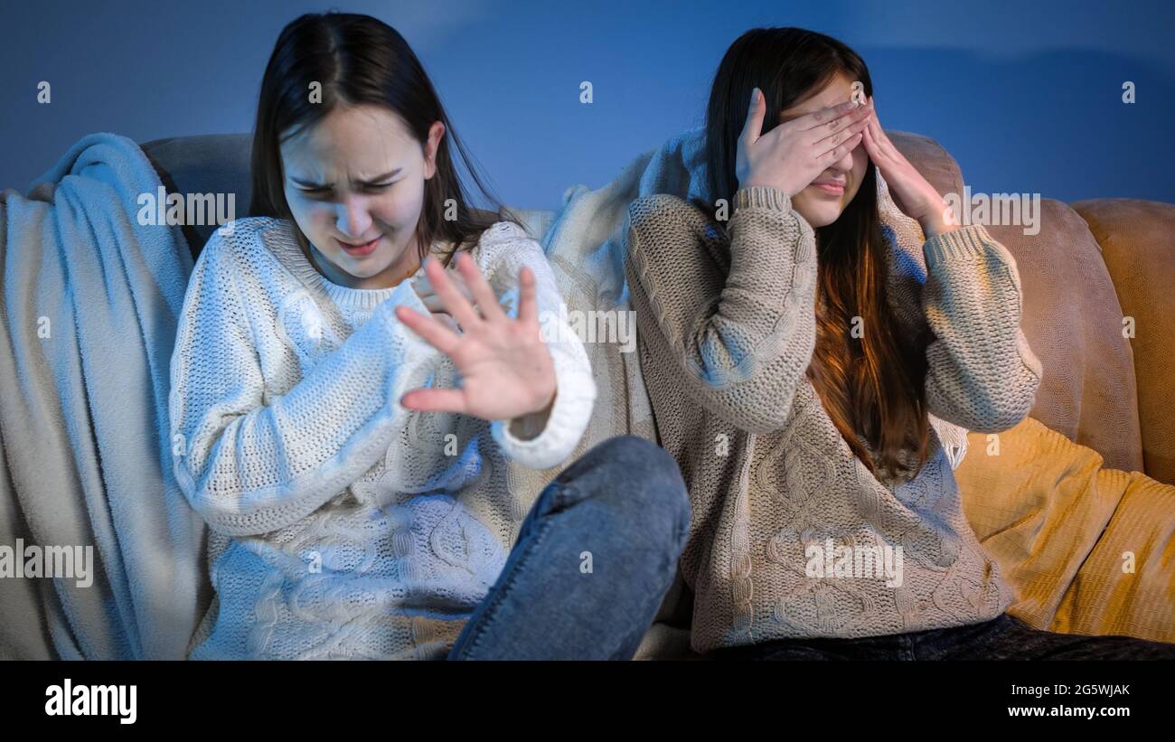 Deux filles regardent effrayantes ou mauvaise émission de télévision et se sentent dégoûtantes Banque D'Images