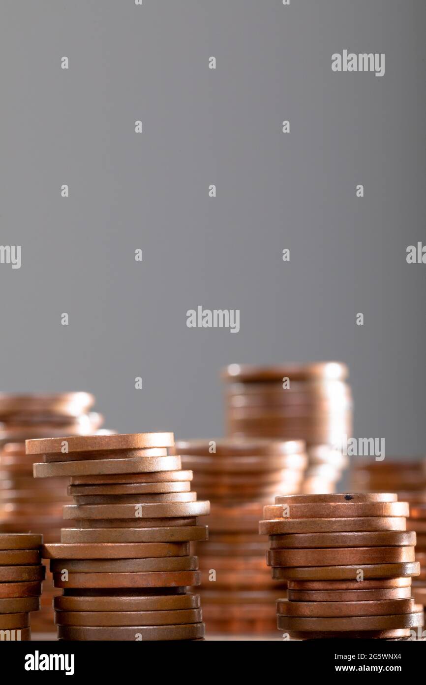 Gros plan de piles de pièces de monnaie sur table, isolées sur fond gris Banque D'Images