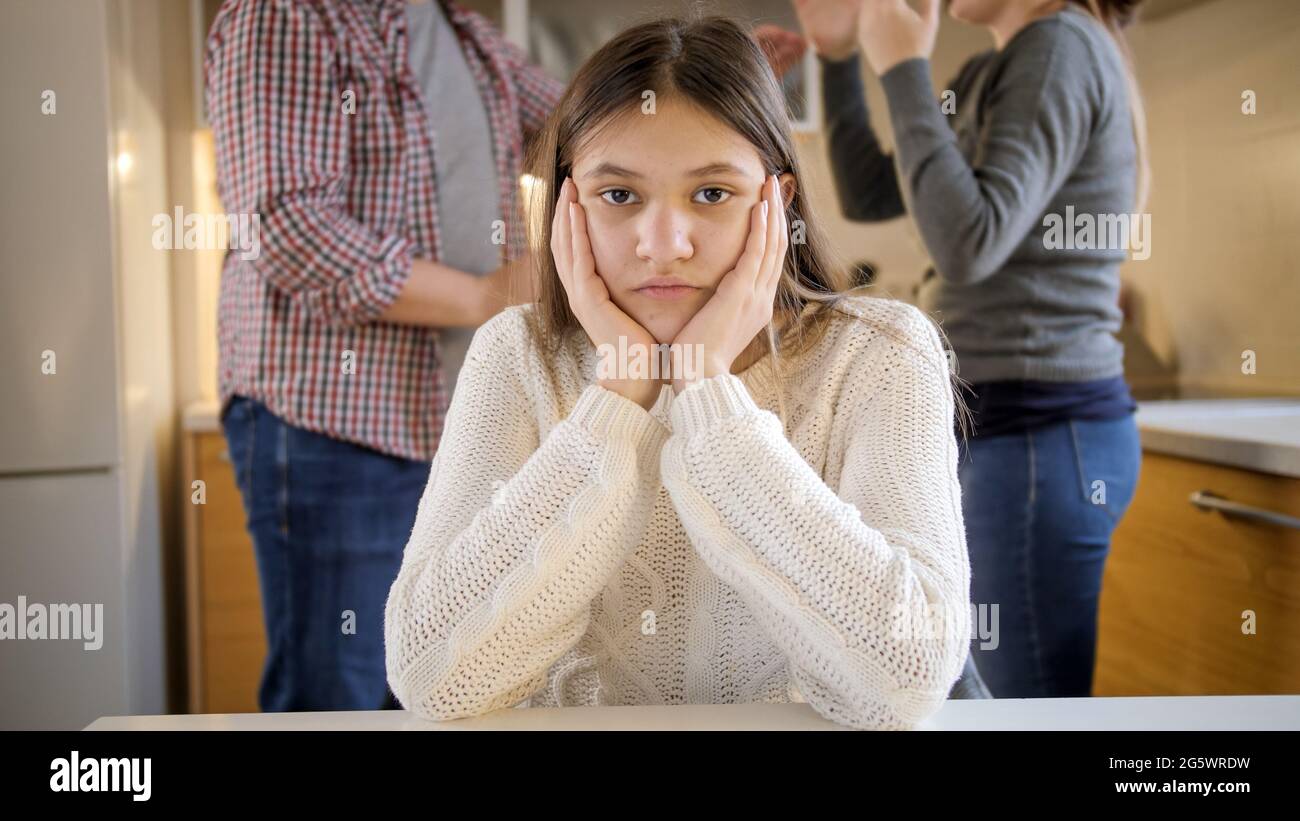 Portrait d'une adolescente regardant dans l'appareil photo et ignorant les parents criant et hurlant pendant le conflit. Violence familiale, conflits et relations Banque D'Images