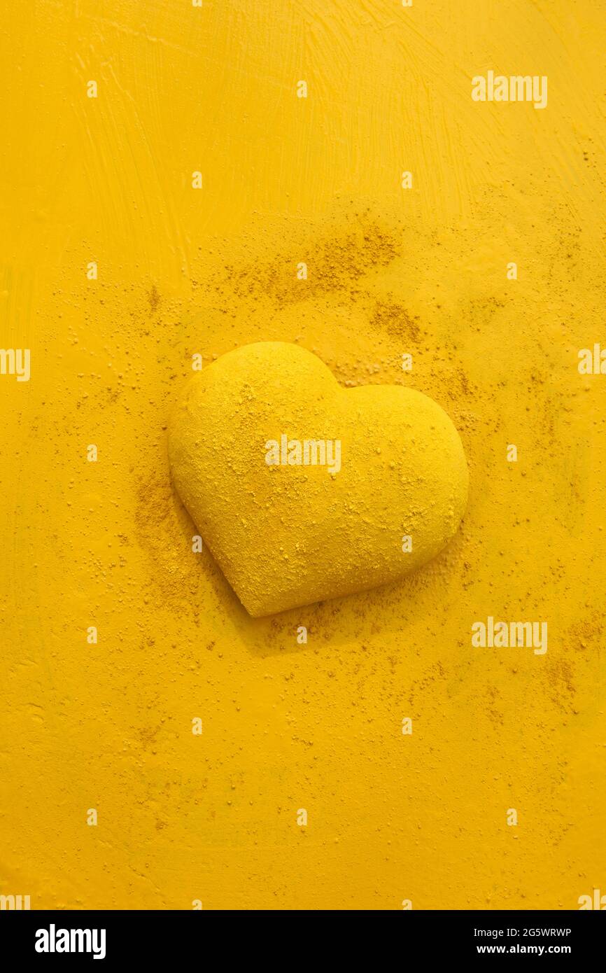 forme de coeur en 3 dimensions, parsemée de peinture jaune et parsemée de pigment sec. La peinture utilisée est Gerstaecker Creativ Pigmente (Gerstaecker Cr Banque D'Images