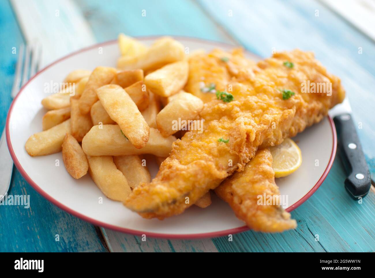 Assiette de morue frite en pâte avec une portion de grosses frites Banque D'Images