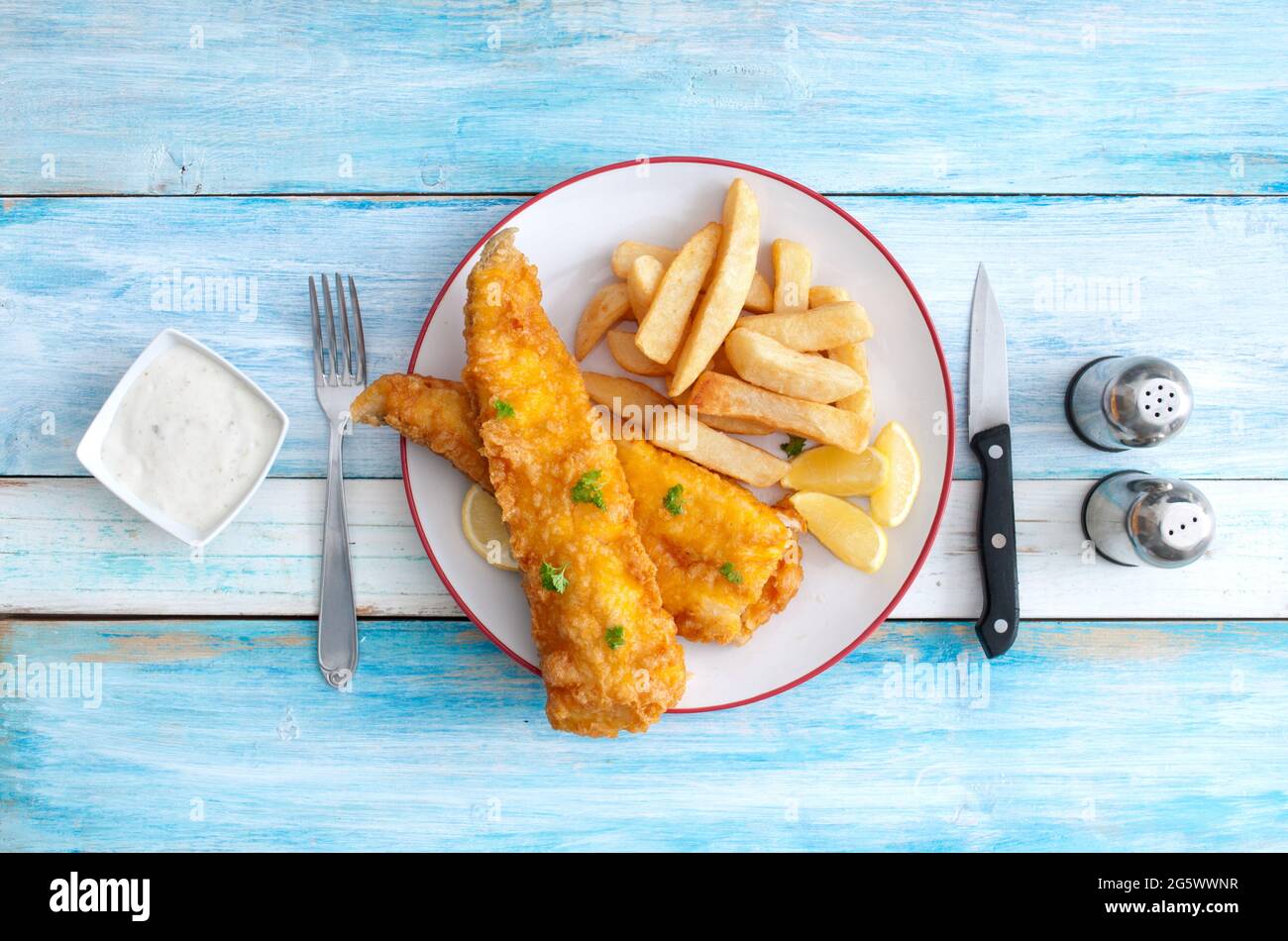 Poisson et frites traditionnels sur une assiette sur une table en bois rustique Banque D'Images