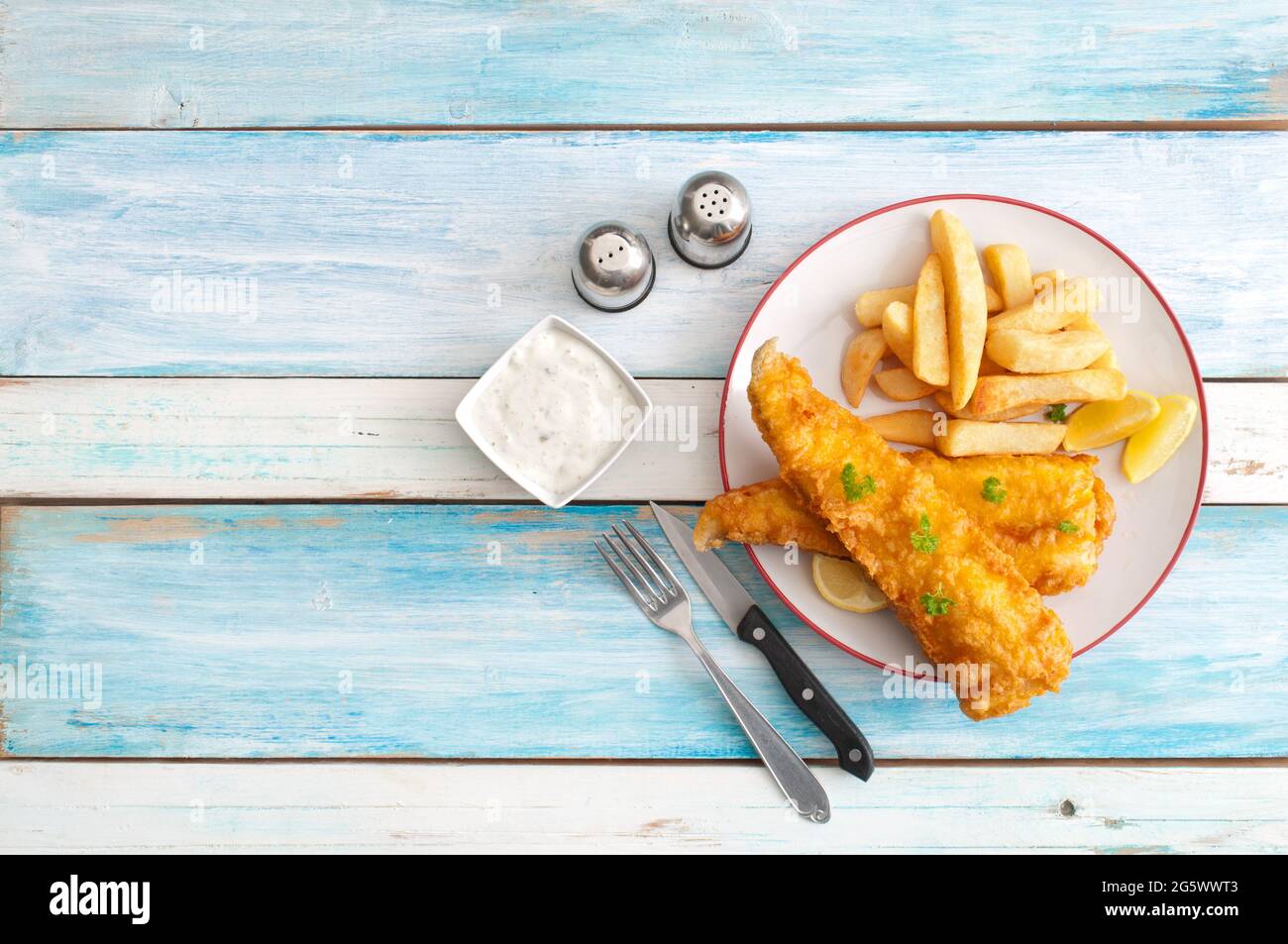 Morue frite avec frites sur une table en bois Banque D'Images