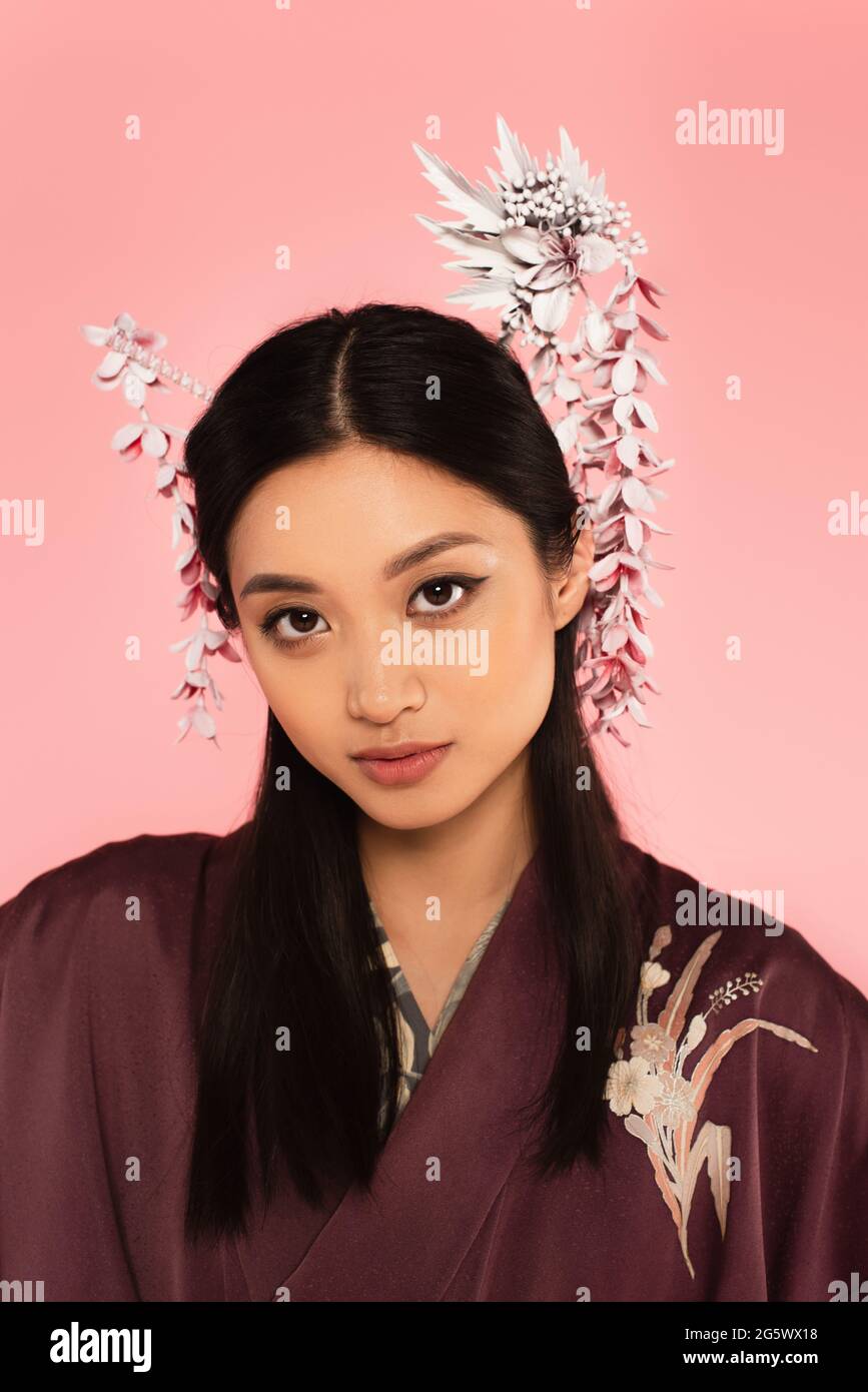 Jeune femme asiatique avec une coiffure traditionnelle isolée sur rose Banque D'Images