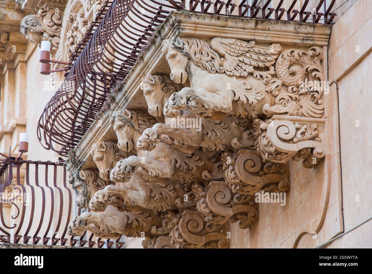 Noto, Syracuse, Sicile, Italie. Des figures de pierre finement sculptées soutenant un balcon ornemental sur la façade baroque du Palazzo Nicolaci di Villadorata. Banque D'Images