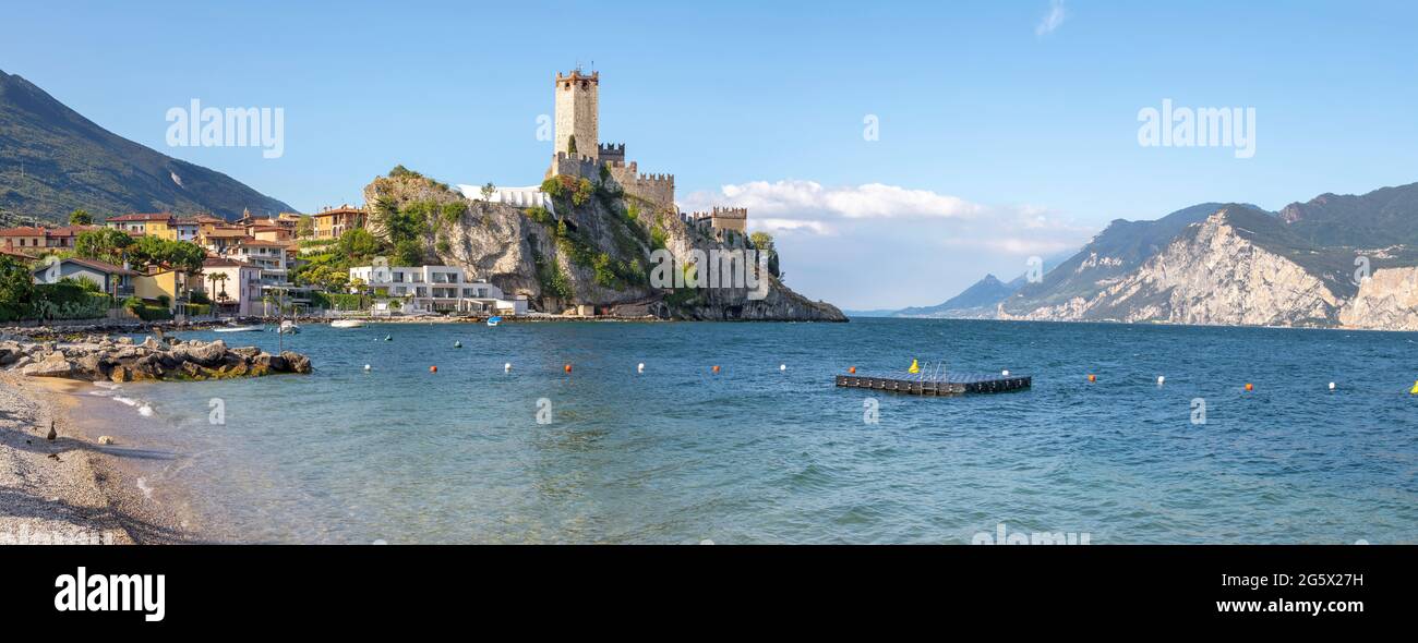 Malcesine - La plage de Lago di Garda Lake avec la ville et le château en arrière-plan. Banque D'Images